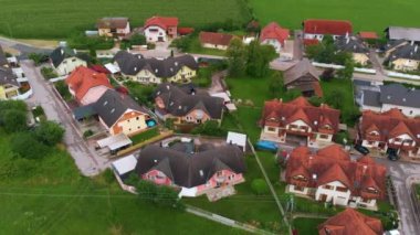 Avrupa 'da manzaralı, ekili tarlalı, ağaçlı ve sokak manzaralı bir köyün hava görüntüleri, insansız hava aracı solda uçuyor.