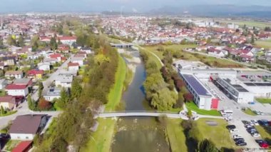 Slovenya, Orta Avrupa 'daki Domzale kasabasındaki küçük bir nehir ve köprünün havadan aşağı eğimli görüntüsü