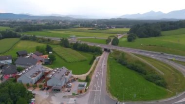 Arka planda Slovenya Avrupa 'da kasaba evleri, ana yollar, sokaklar, manzara ve ağaçların yer aldığı bir köyün soldaki görüntülerine hava desteği