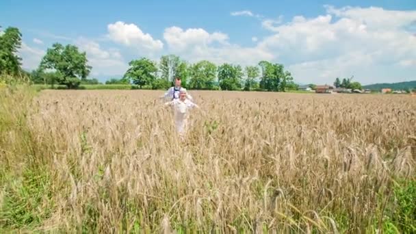 Niños Saltando Través Del Campo Trigo Con Los Brazos Hacia — Vídeos de Stock