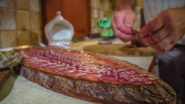 Eller ahşap kesme tahtasına sosis yerleştiriyor. Statik çekim