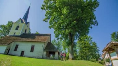 Yürüyüşçü beyaz çift Slovenya 'daki St.George Kilisesi Slovenya Gradec' e baktılar