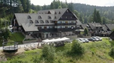Slovenya 'da güneşli bir günde Kope alp disiplini kayak merkezi ve otel Lukov Dom' un havadan çekimleri