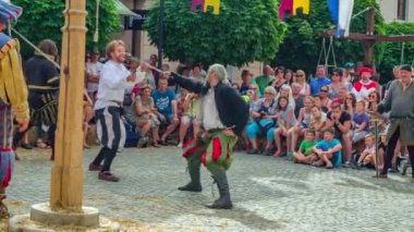 Ortaçağ pazarında tarihi geçmişi olan kılıç dövüşü gösterisi yavaş çekimde gerçekleşiyor.