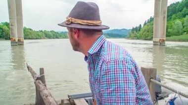 Drava Nehri 'ndeki ahşap sala yol gösteren bir adamın ağır çekimi..