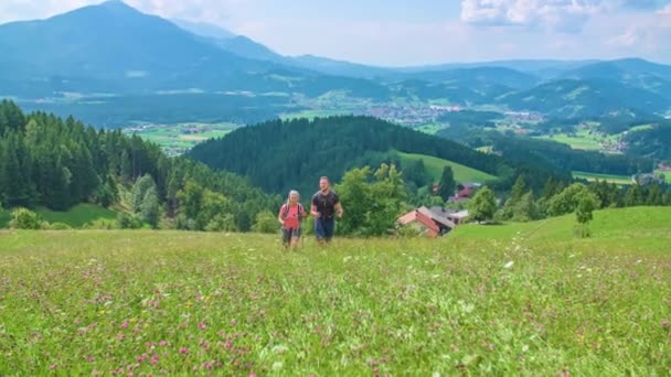 Mladý Pár Kráčí Květinové Louce Kopci Zákulisí Kopce Smrkovým Lesem — Stock video