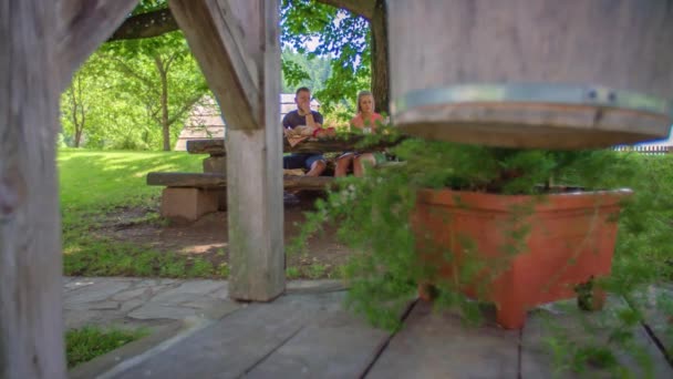 柱の後ろにドリーワイドショット カップルは座って テーブルの上に屋外で食べる 低角度選択的フォーカス — ストック動画
