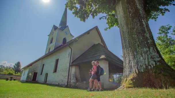 Двоє Молодих Мандрівників Ходять Своїми Пішохідними Полюсами Повз Церкву Гарний — стокове відео