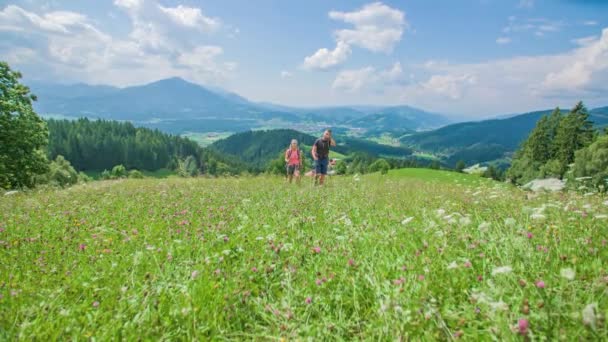 Mladí Turisté Pár Trekking Údolí Květin Obklopen Krásnými Horami Zpomal — Stock video