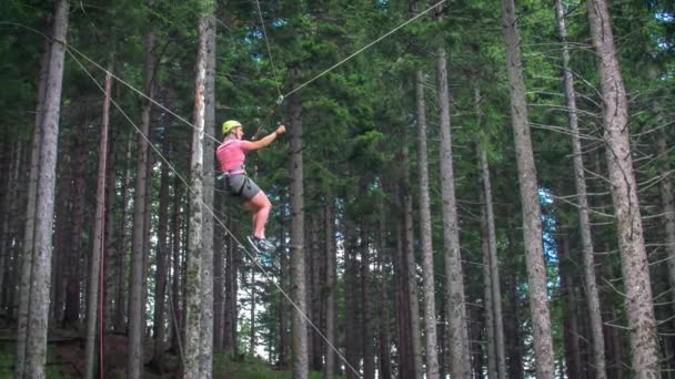 Mujer Colgando Tirolina Rebotando Arriba Abajo Dentro Del Bosque Pinos — Vídeo de stock