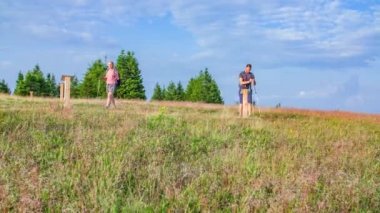 Kırsalda yürüyüş yapan genç bir çiftin fotoğrafı.
