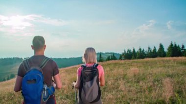 Yürüyüş yapan doğa yürüyüşçüleri. Yürüyüş sırasında yürüyen kadın ve erkek yürüyüşçüler. Sabit çekim.
