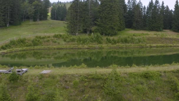 スロベニアの自然の中で荒野の湖で電気自転車に乗って 湖によって運転する男性の空中追跡パンショット — ストック動画