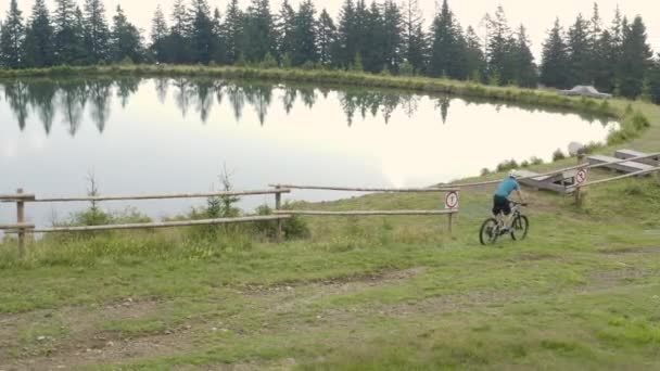 านข างทางอากาศ ภาพการต ดตามม าของคนท กรยานเส เขาไฟฟ าในถ นดารข างทะเลสาบในสโลว — วีดีโอสต็อก