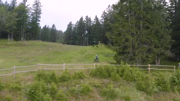 スロベニアの人里離れた荒野でマウンテンバイクを運転している白人男性の空中横からの攻撃ショット — ストック動画