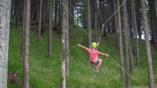 木の間の大きなぶら下がりスイングに自由にスイングすることによって達成され 幸せな冒険的な若い女性の気持ち スローモーション — ストック動画