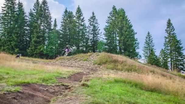 Montanha Ciclistas Executar Turn Bar Truques Mesa Sobre Downhill Jump — Vídeo de Stock