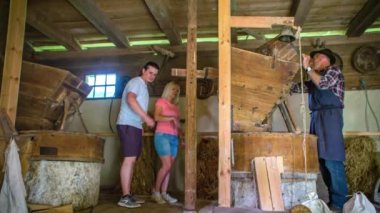 İki turist, Sloven Povhov değirmeninde çalışan işçiyle birlikte eski bir değirmende turneye çıkıyor.