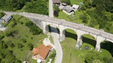 Slovenya 'daki demiryolu kemeri köprüsünün altındaki ücra kırsal yolda bisiklet süren iki bisikletçi