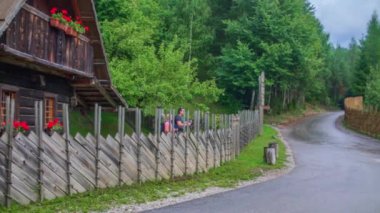 Yürüyüşe hazır iki kişi büyük bir kulübeden çıkıyor..