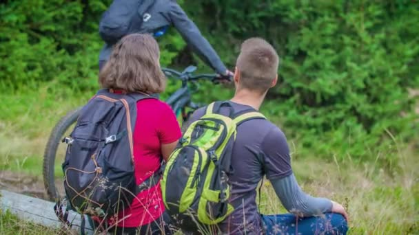 Retkeilijät Istu Lepää Katso Kaksi Pyöräilijää Ratsastaa Menneisyyden Metsässä Käyttää — kuvapankkivideo