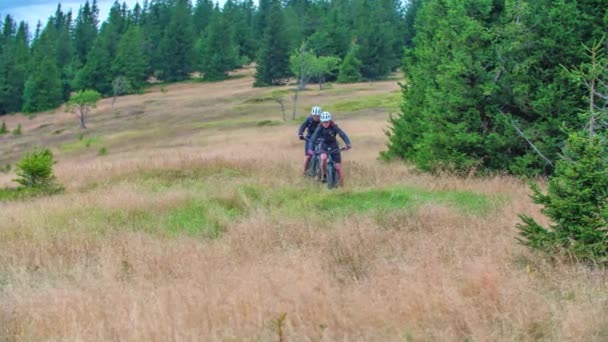 Два Горных Велосипедиста Едут Горному Ландшафту Покрытому Сухой Травой Разбросанными — стоковое видео