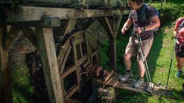 徒步旅行者们在科罗卡参观了一座传统的木制水磨坊 把手中的水当作点心 — 图库视频影像