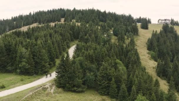 Vista Ciclistas Subiendo Por Carretera Colinas Rodeadas Árboles Antena — Vídeos de Stock