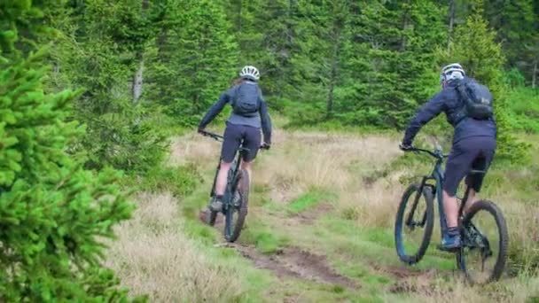 マウンテンバイクのカップルは スローモーションで森の歩道を自転車に乗っています — ストック動画