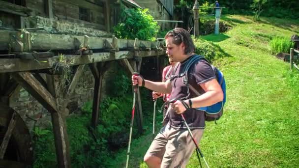 徒步旅行者在穿过乡村时停下来看传统的水车磨坊 — 图库视频影像
