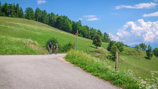 Couple Vélo Sur Route Green Hill Background Gros Plan Ralenti — Video