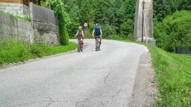 ストッパーの橋の下を数人の自転車が走っている 背景に美しい古代の橋の眺め — ストック動画