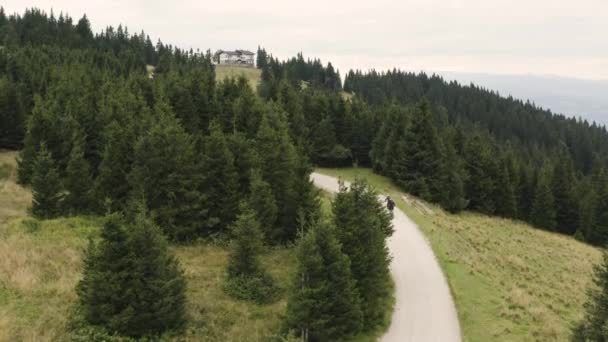 Ciclistas Subir Estrada Hills Rodeados Por Árvores Pedestal Aéreo — Vídeo de Stock