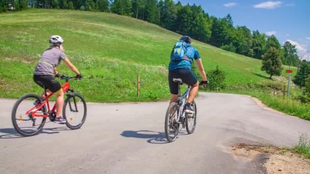 Ένα Ζευγάρι Που Φοράει Εξοπλισμό Ασφαλείας Ποδήλατα Διασχίζει Την Εξοχή — Αρχείο Βίντεο