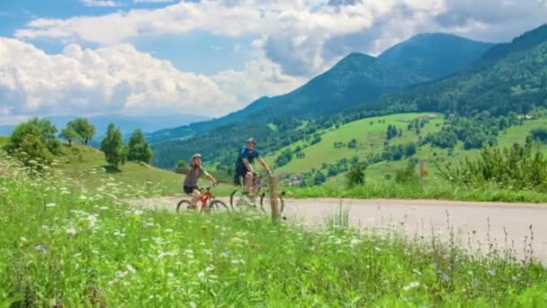 年轻的一对夫妇骑在乡间自行车上 背景色迷人 绿树成荫 — 图库视频影像