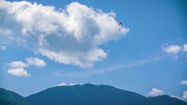 Slovenya, Kotlje 'de bulutlu mavi gökyüzüne doğru uçan paraglider