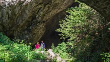 Slovenya 'nın Doliç kentinde Huda Luknja' da genç bir adam ve kadın yürürken, kamera yavaşça aşağı kayıyor.