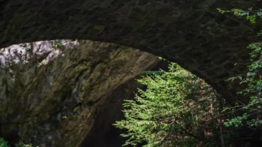 Slovenya 'nın Doliç kentinde Huda Luknja' da yürüyen erkek ve kadın kameralar bir akıntıyı açığa çıkarıyor.