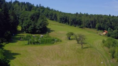 Ravne na Koroskem 'deki yeşil tarlaların ve ormanın manzarası.
