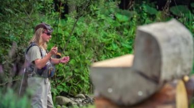 Uzun saçlı balıkçı nehirde balık tutuyor, Podvelka, Slovenya 'da el sallıyor