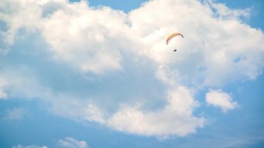 Mavi gökyüzünde paraglider. Paraşüt üzerinde uçan sporcu..