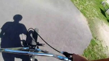 BMX motosikletçisi pompa pistinde diğerlerini takip ediyor asfalt, Action Body Camera View yarı hız