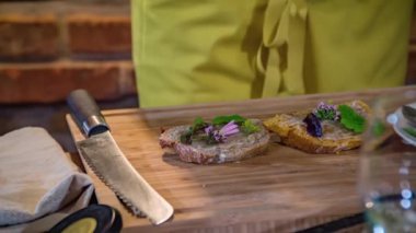 Bir aşçının geleneksel bir Slovenya yemeği, sebzeler, otlar ve ekmeklerle servis ederken yakın plan fotoğrafı.