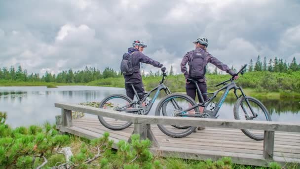 Two Young Sportsmen Bicycles Standing Lake Watching Green Countryside — Stock Video