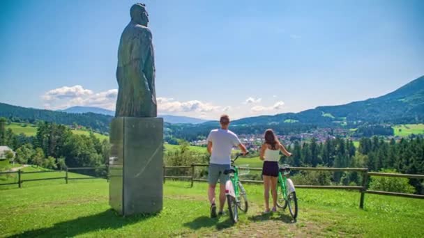 位于斯洛文尼亚Kotlje市Lovro Kuhar Preihov Voranc 雕像附近的一对年轻夫妇 — 图库视频影像