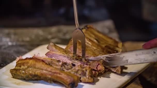 近距离拍摄一个人在切菜板上把一块猪肉切成排骨片 — 图库视频影像