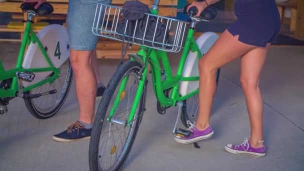 一对年轻夫妇抓起两辆出租自行车开始骑车的慢镜头 — 图库视频影像