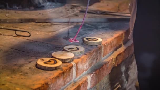 用红热的铁棍在小块木头上贴上心形图案的工匠的近照 — 图库视频影像