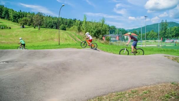 Young Teenagers Riding Bikes Jumping Pump Track Sunny Day Slow — Stock Video