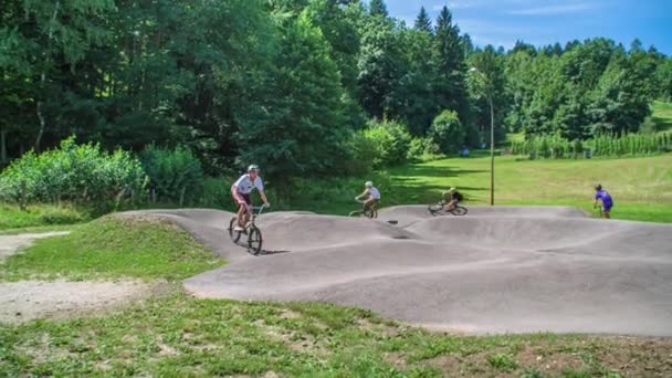 Barn Cyklar Snabbt Runt Pumpbanan Unge Skoter Solig Dag Slovenien — Stockvideo